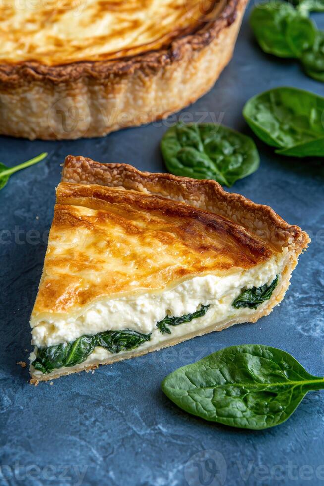 Delicious spinach and feta quiche slice on dark background photo