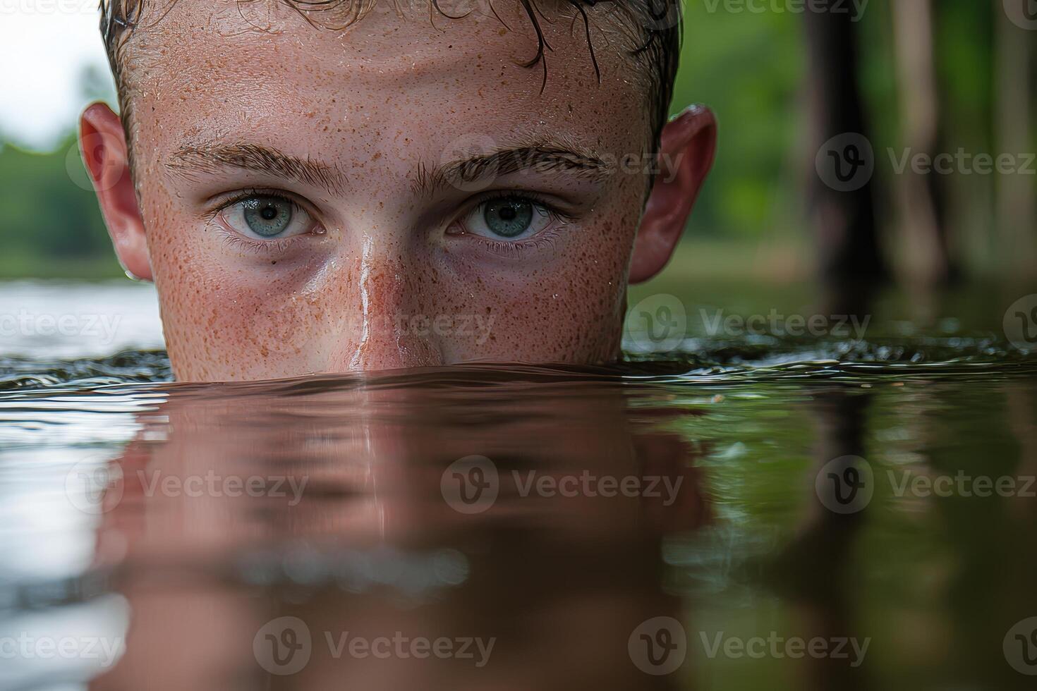 Close up of a boys face peeking out of the water photo