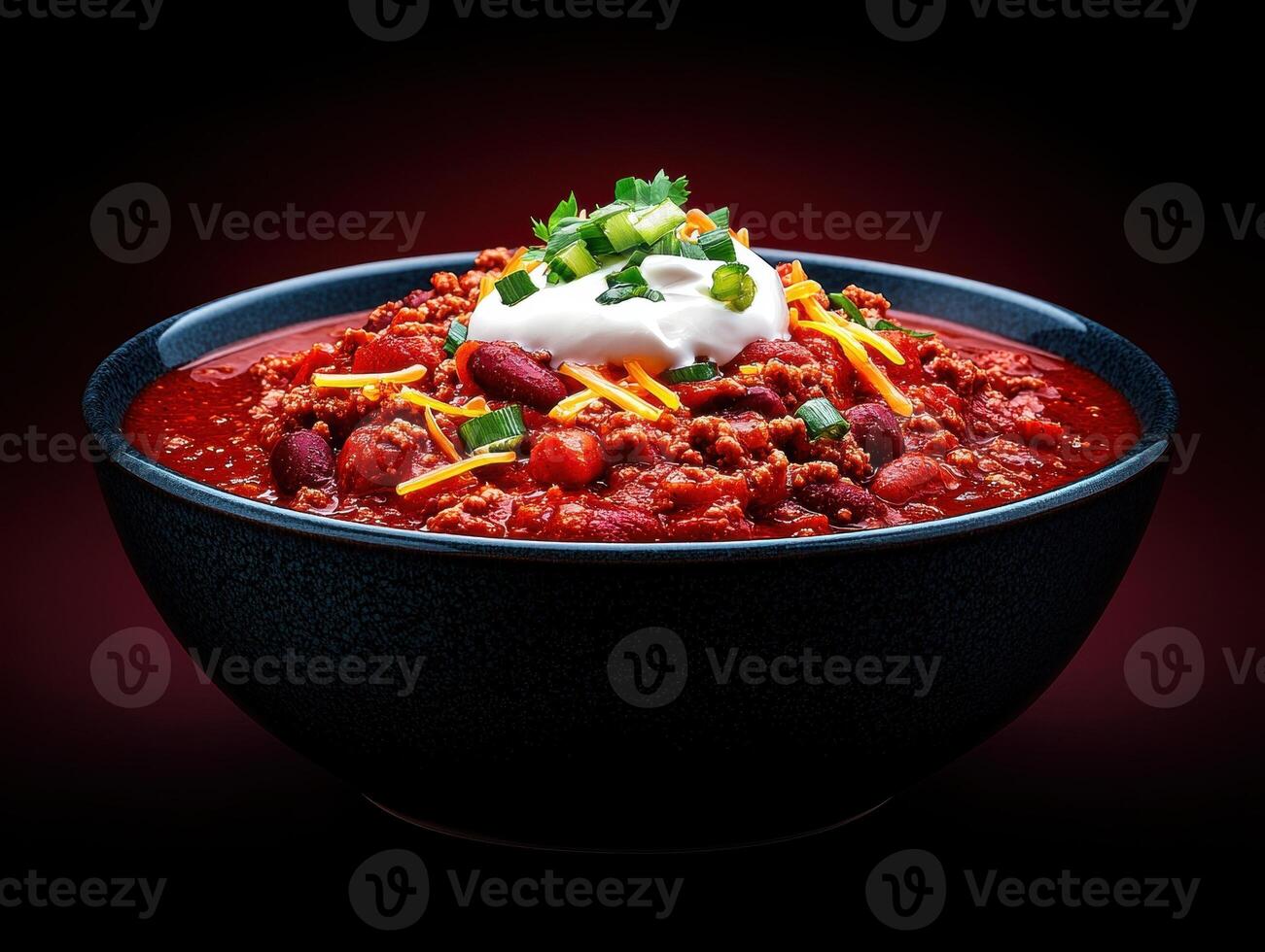 A bowl of gourmet chili topped with sour cream and cheese photo