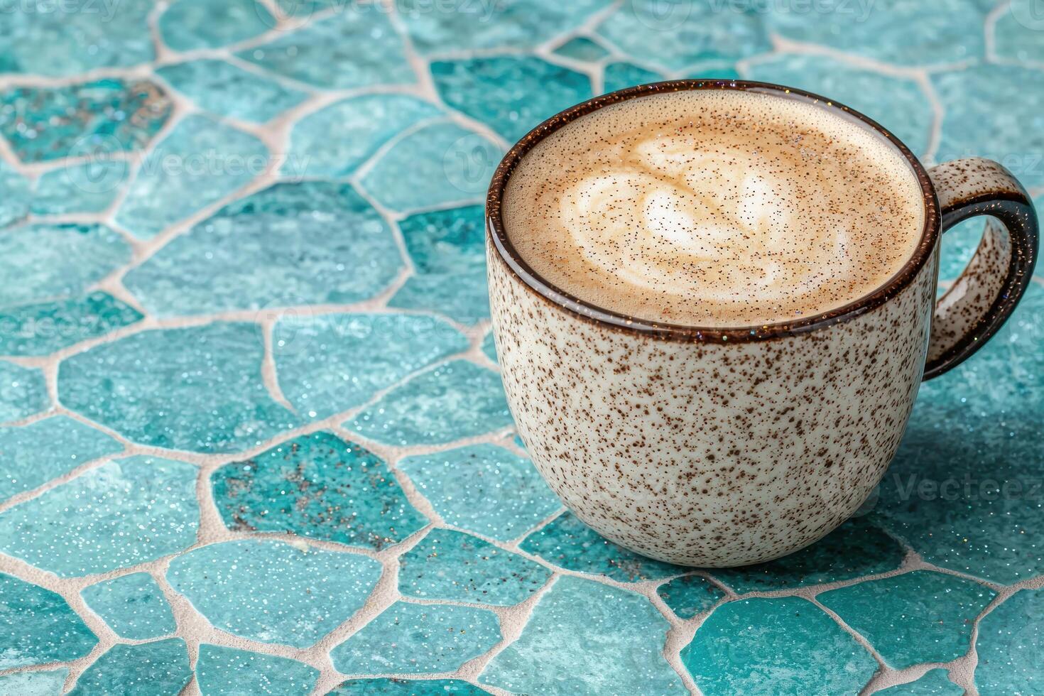 Close up of a cup of latte art on a teal mosaic table photo