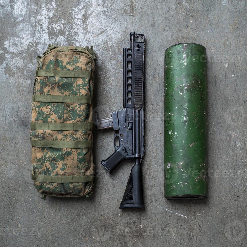 Military assault rifle, ammunition, and tactical backpack on a concrete surface photo