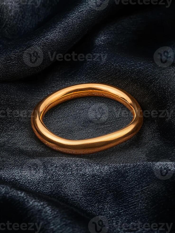 Gold ring on dark silk fabric photo