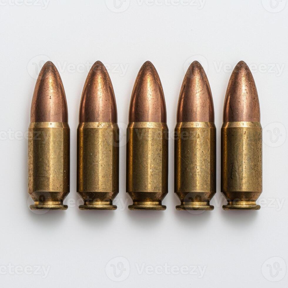 Five bullets lined up in a row on a white background photo