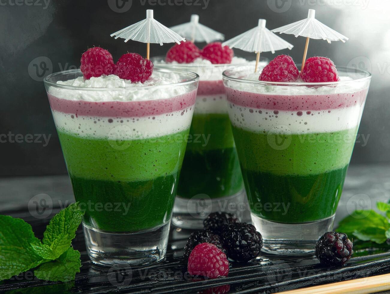 Layered raspberry and green smoothie dessert in glasses photo