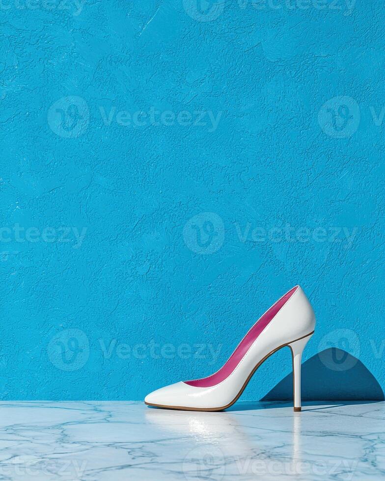 White high heels on marble surface against blue background photo