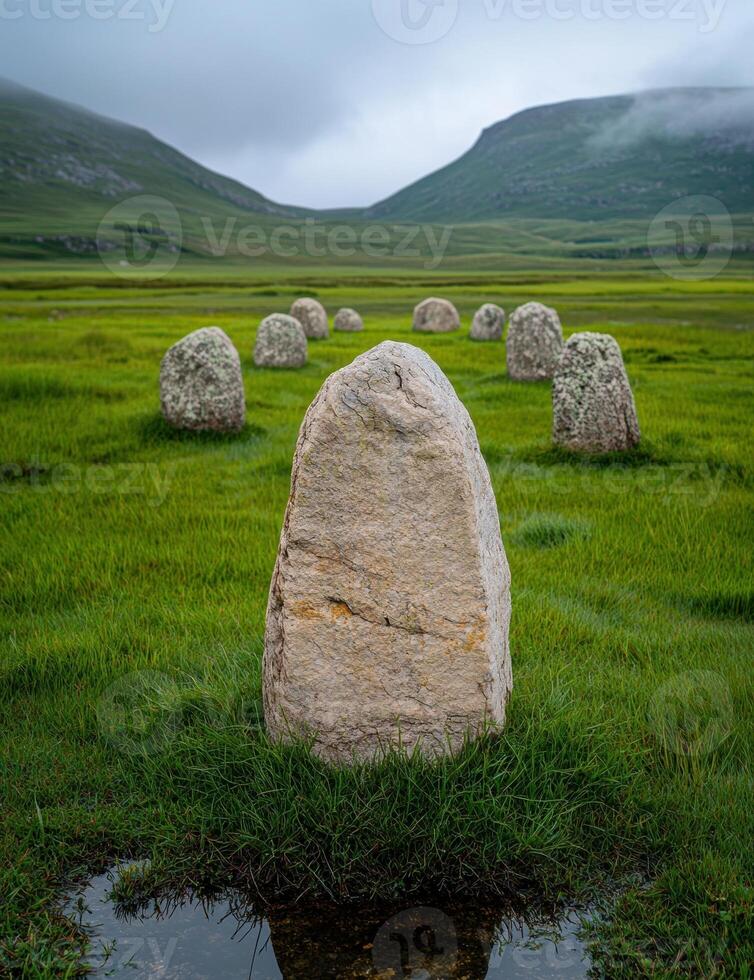 Ancient stone circle in a green field under a cloudy sky photo