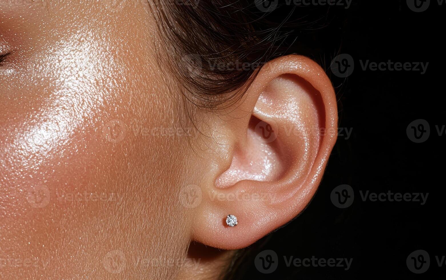 Close up of a womans ear with a small diamond stud earring photo