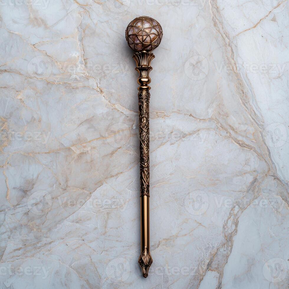 Ornate golden scepter with a gemstone top on a marble background photo