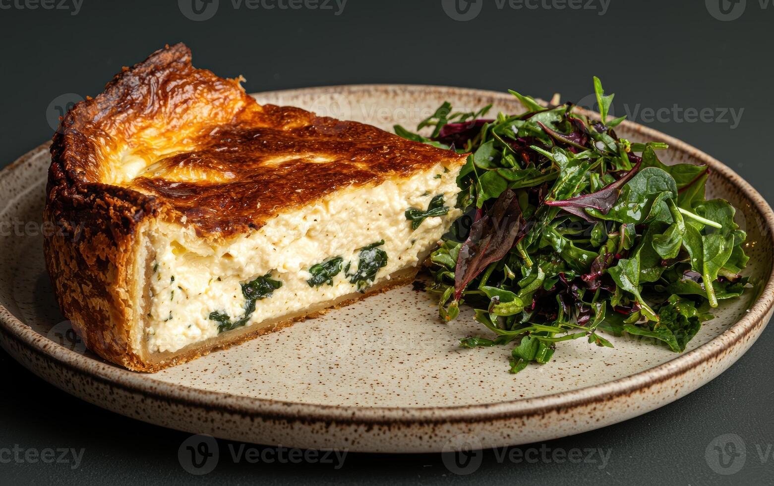 Delicious slice of spinach and feta quiche served with a side salad photo