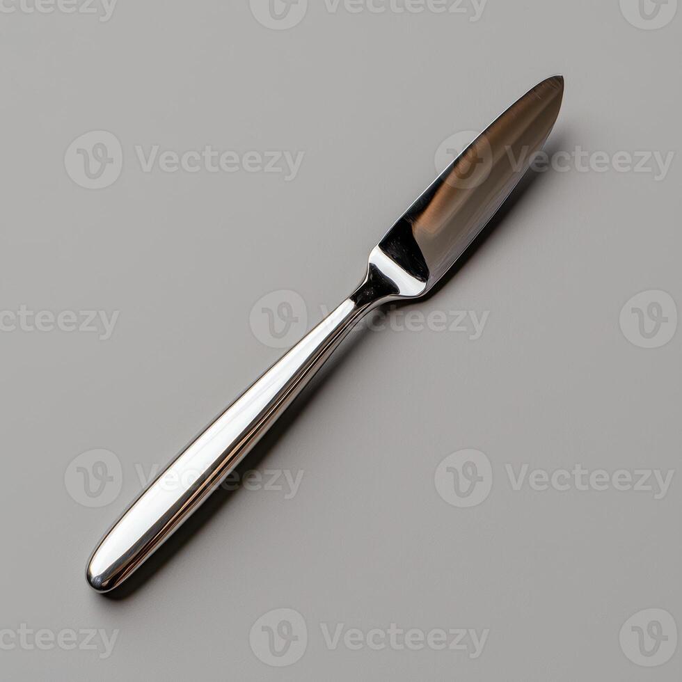 Close up of a sleek, modern butter knife on a gray background photo