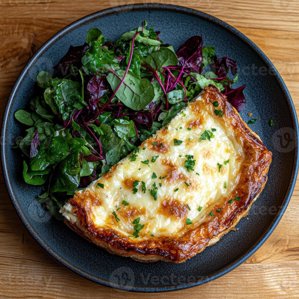 Delicious slice of quiche with fresh salad on dark plate photo