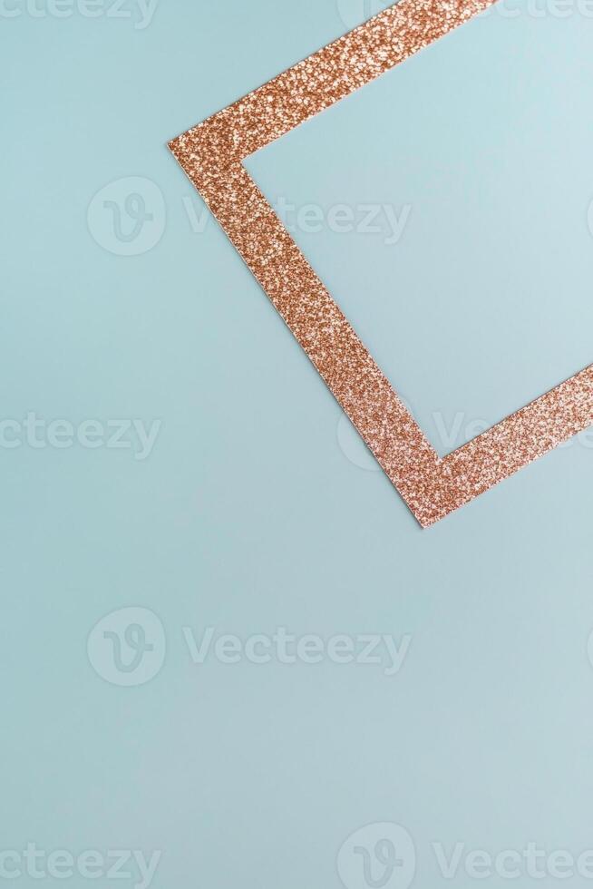 Minimalist geometric composition with a glittery copper triangle on a pastel blue background. photo