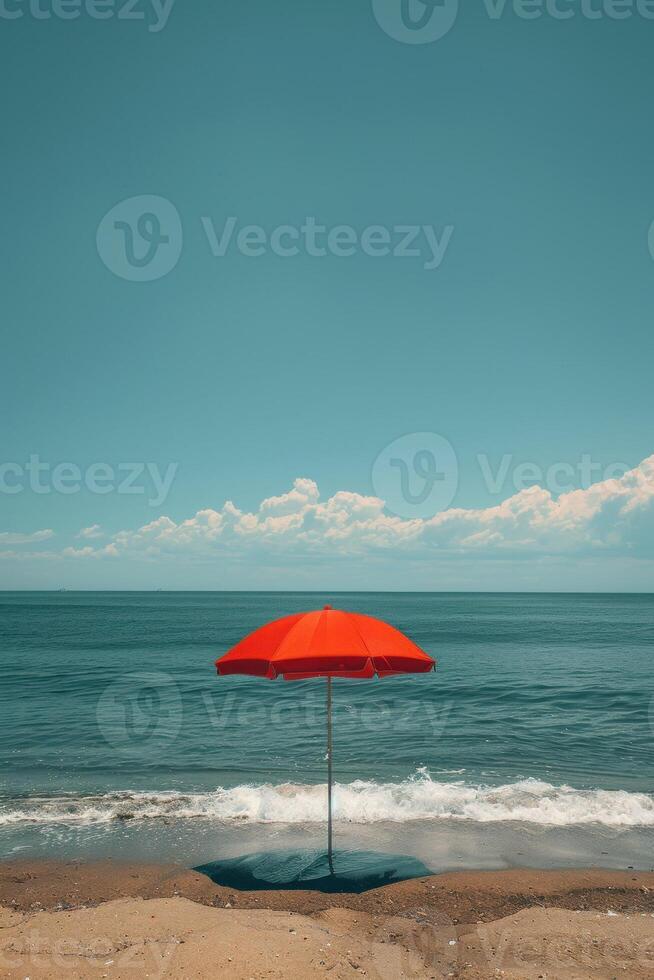 A vibrant red umbrella offers shade on a sunny beach day by the ocean. photo