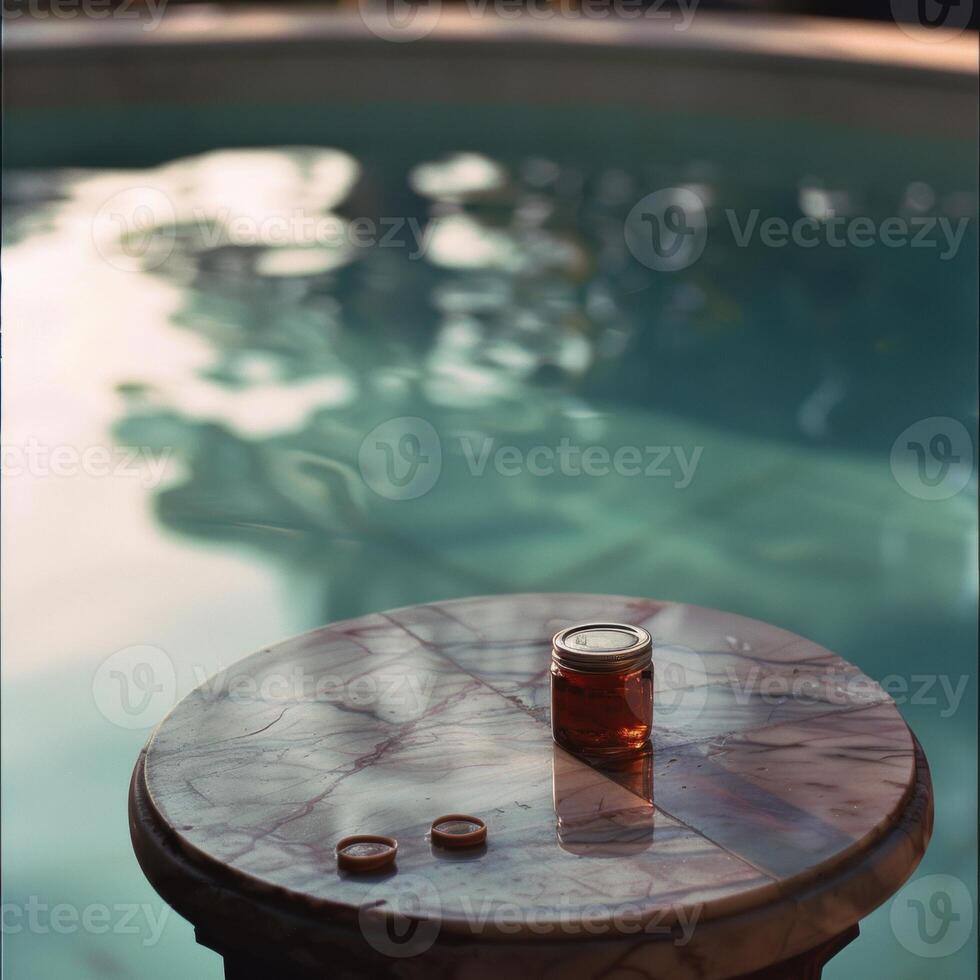 A jar of honey on a marble table by a serene poolside, capturing a tranquil moment. photo