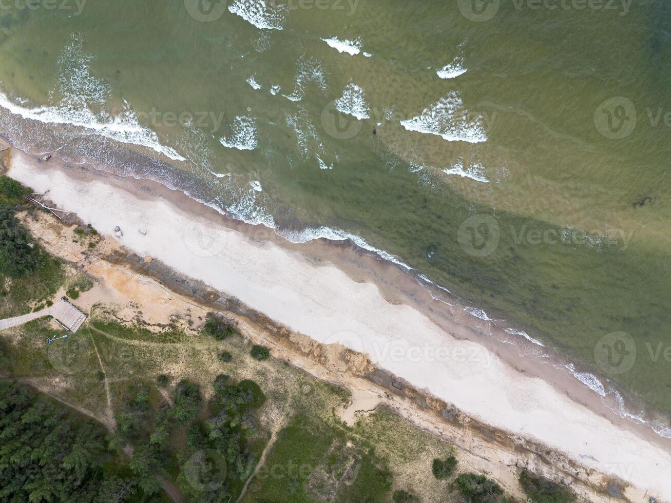 Coast of the Baltic Sea, waves rolling along the sandy shore, view from above. Coast of the Baltic Sea photo