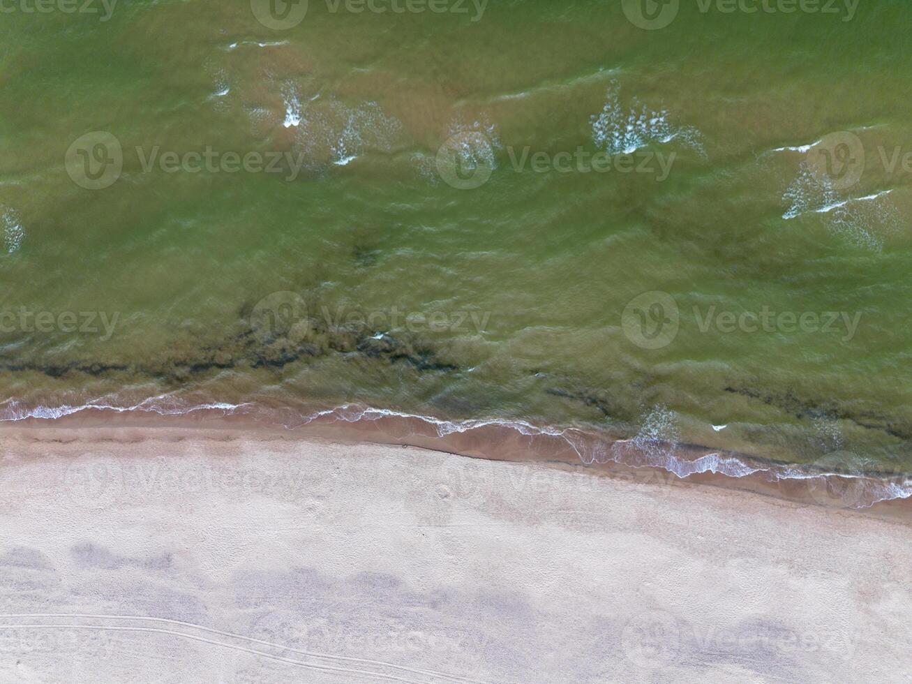 Baltic sea waves rolling on sandy shore, top view. Sea background photo