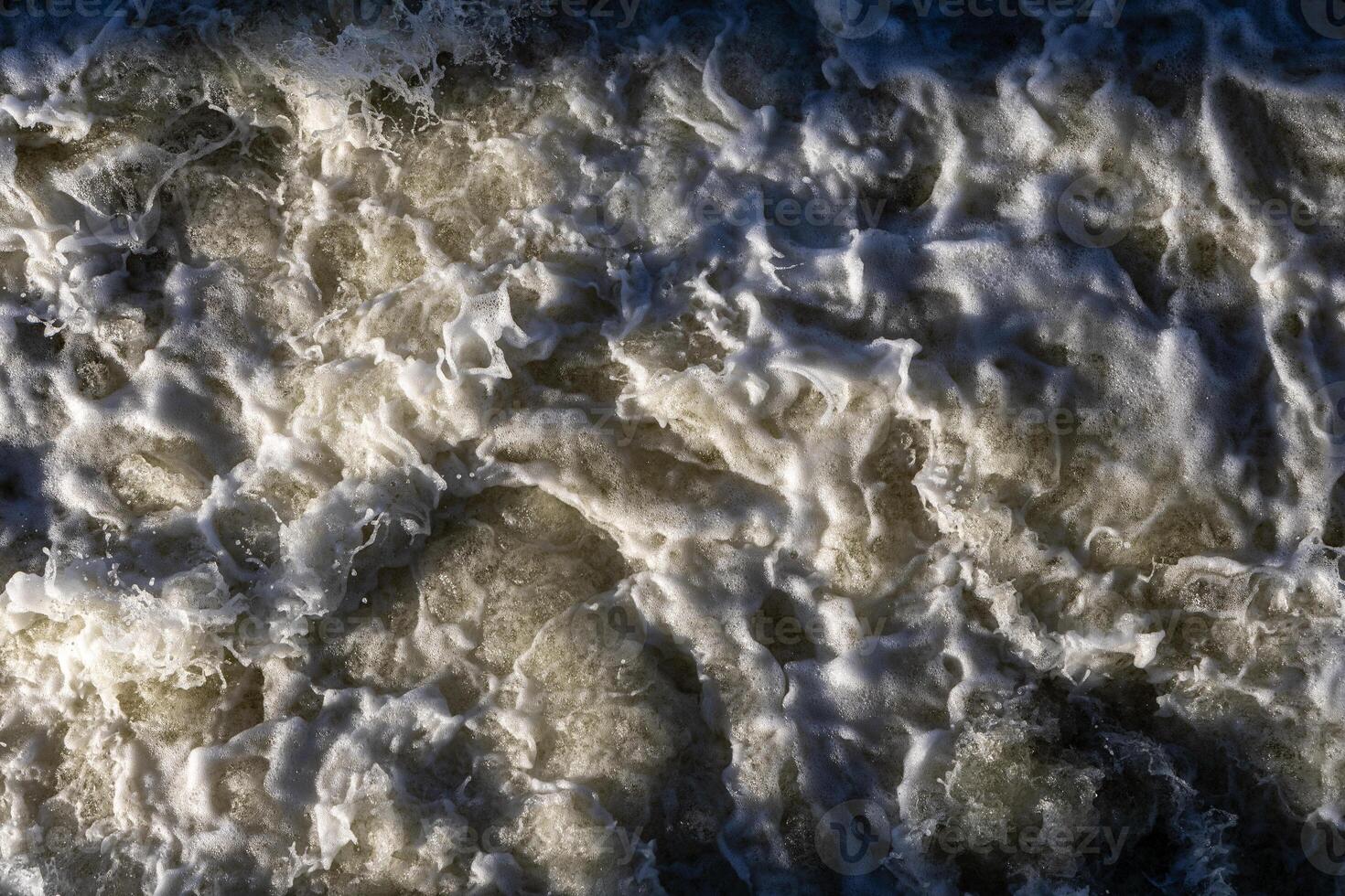 Rough flow of foaming water in the river, close-up, background. Rough flow photo