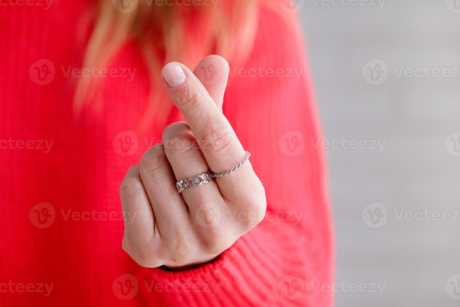 female hand showing heart gesture with fingers photo