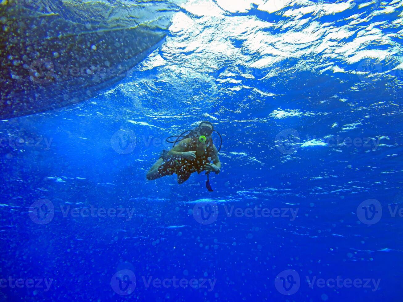 Scuba diver underwater with bubbles and sunlight reflections photo
