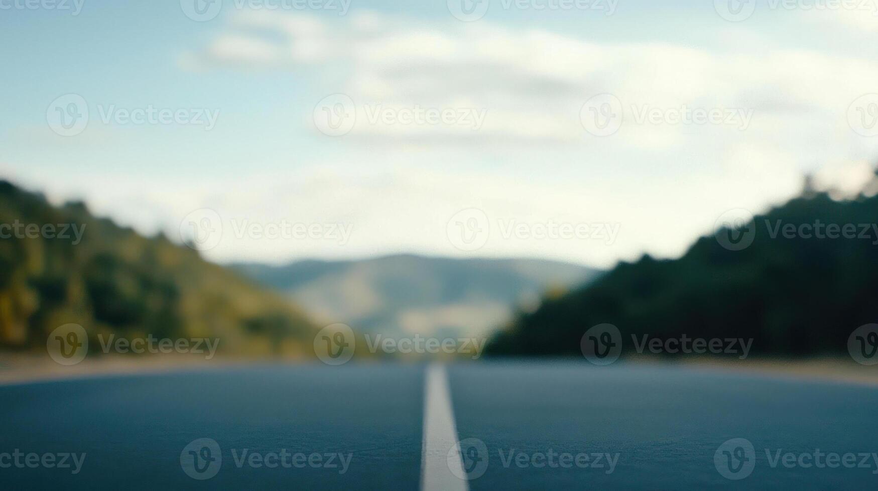 A tranquil view of a road stretching towards distant hills under a clear sky. photo
