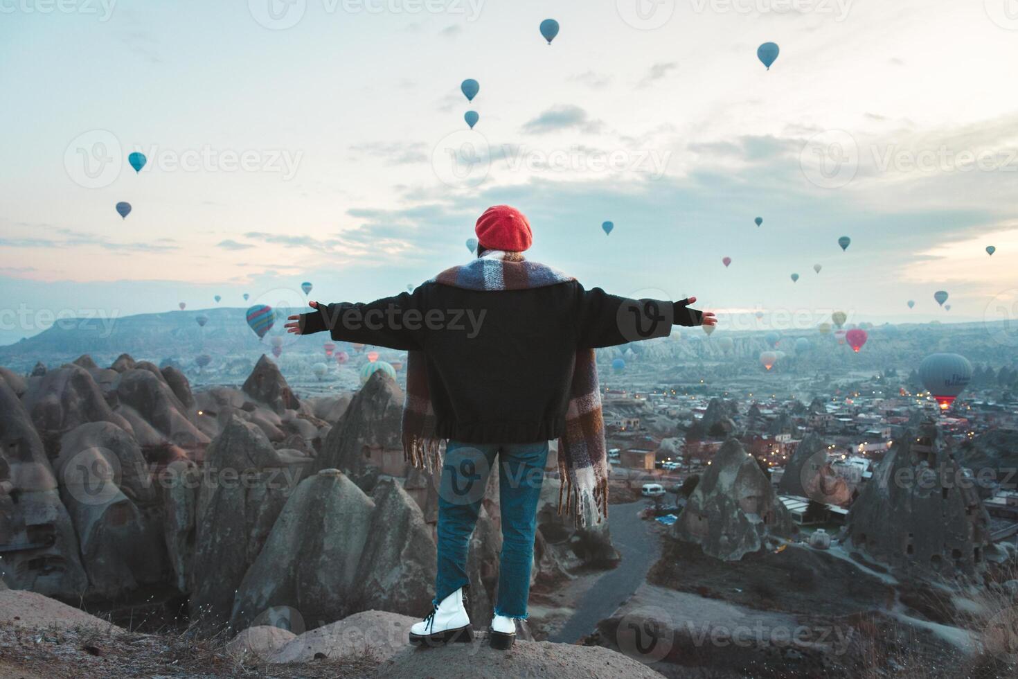 cerca arriba aéreo enfocar fuera ver panorama caucásico mujer solo viajero en punto de vista creciente su manos y mirando en vuelo caliente aire globos en capadocia. amor Valle amanecer en frío invierno Mañana foto