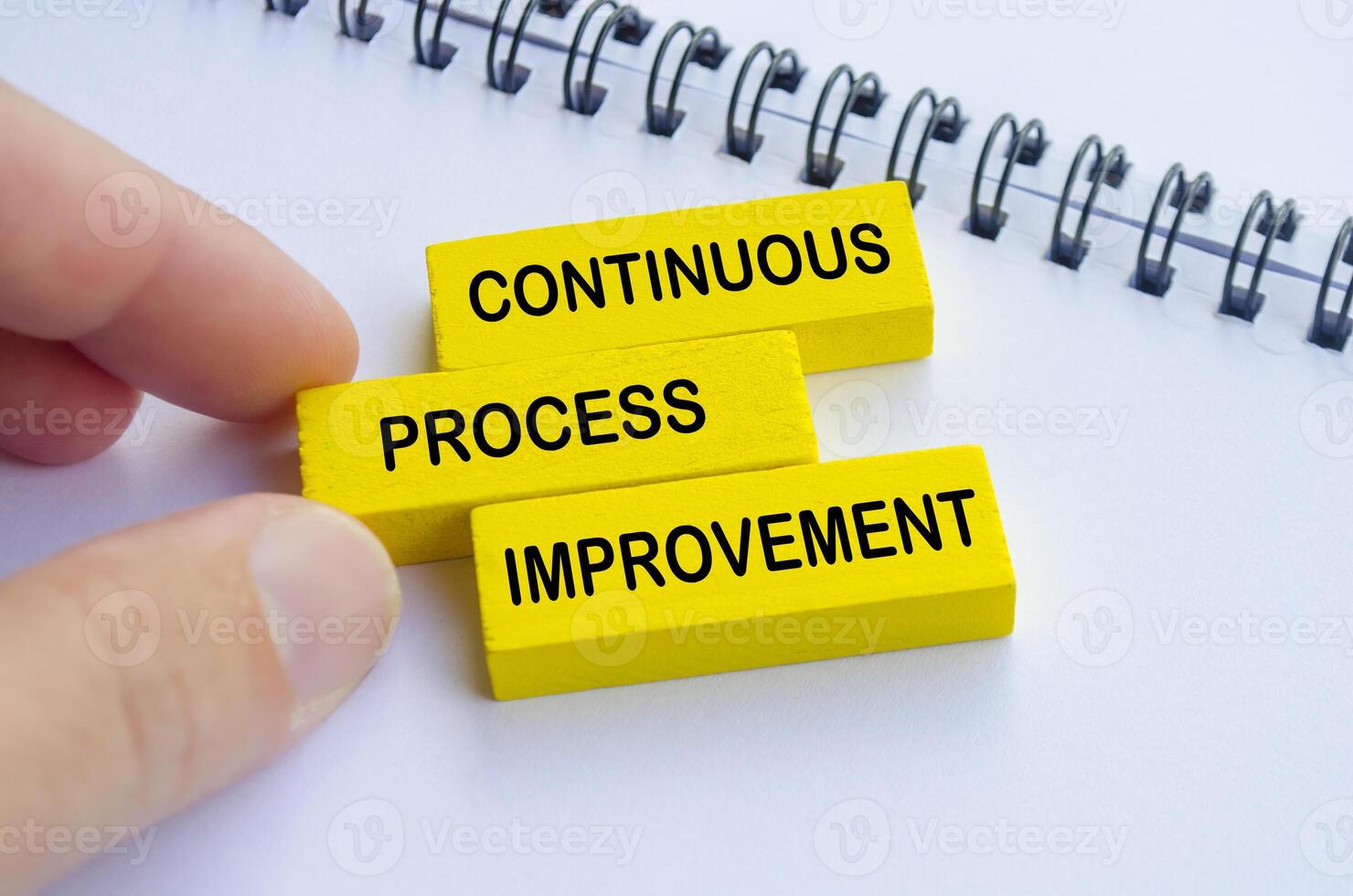 Continuous Process Improvement text on yellow wooden blocks photo