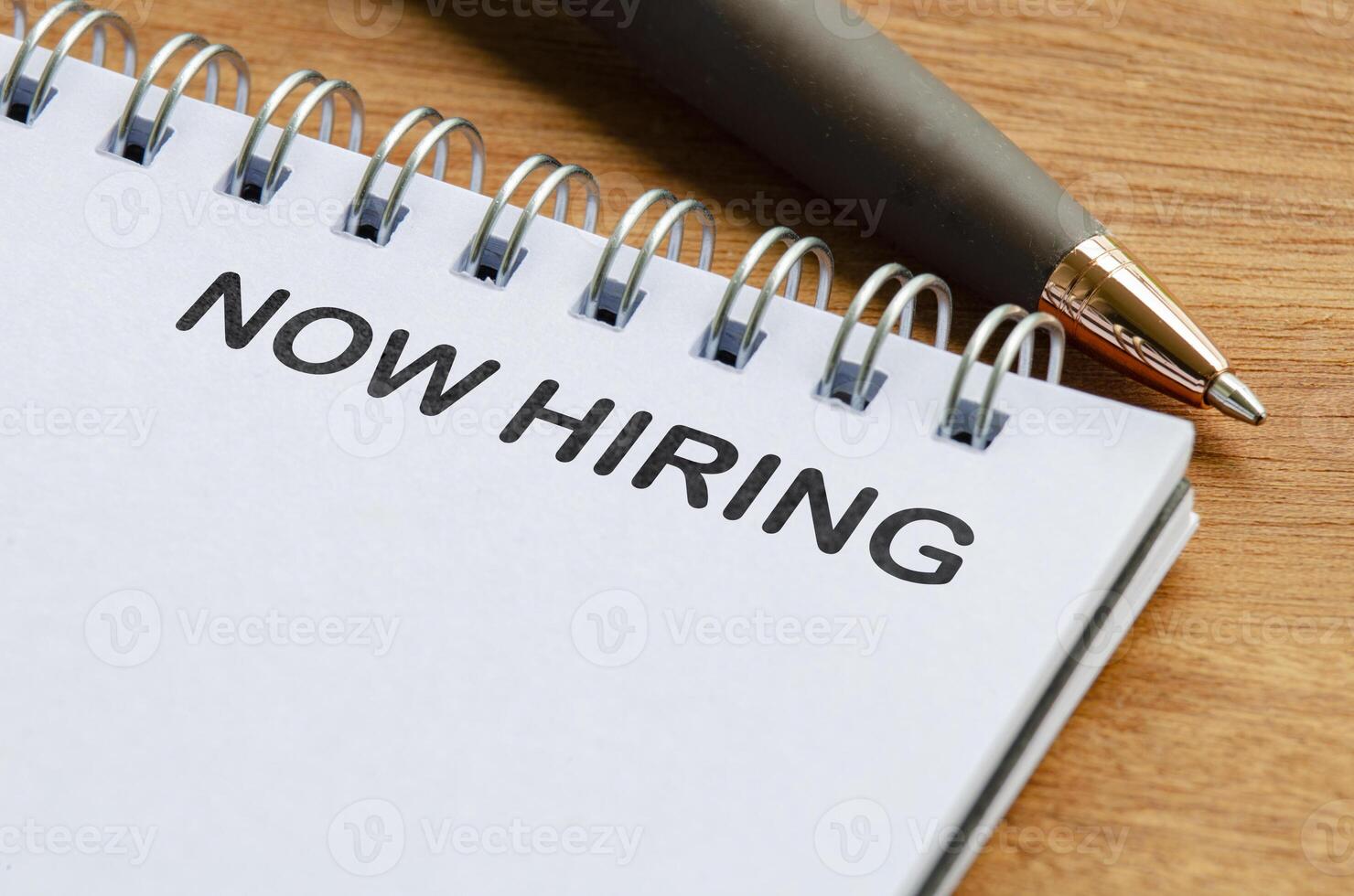 Now hiring text on white notepad. Recruitment and hiring concept photo