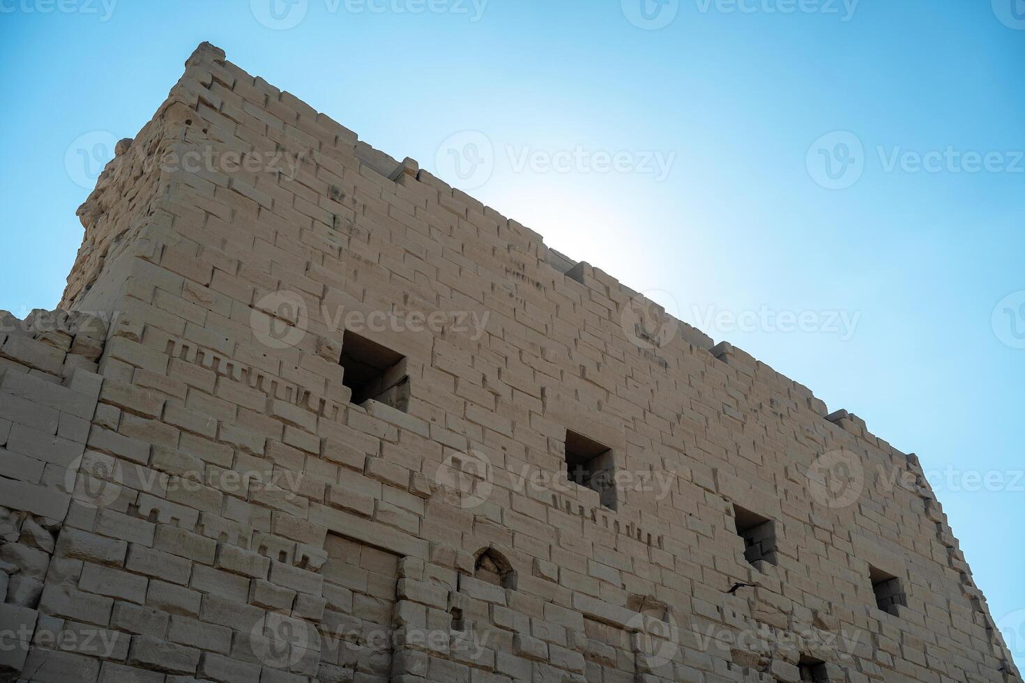 Ancient Egyptian wall in Luxor against the sky photo