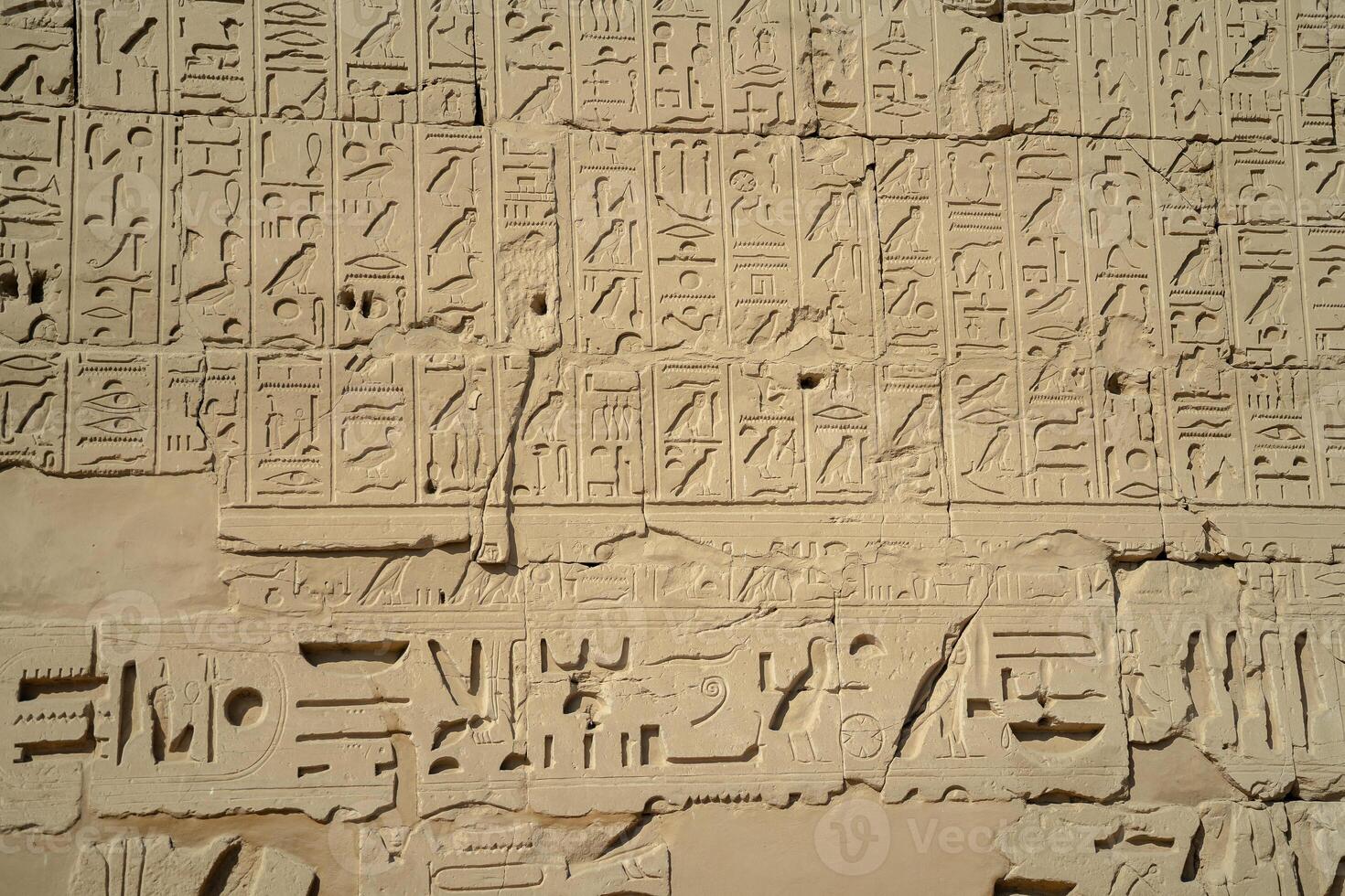 Egyptian ancient wall with hieroglyphs carved in the open air photo