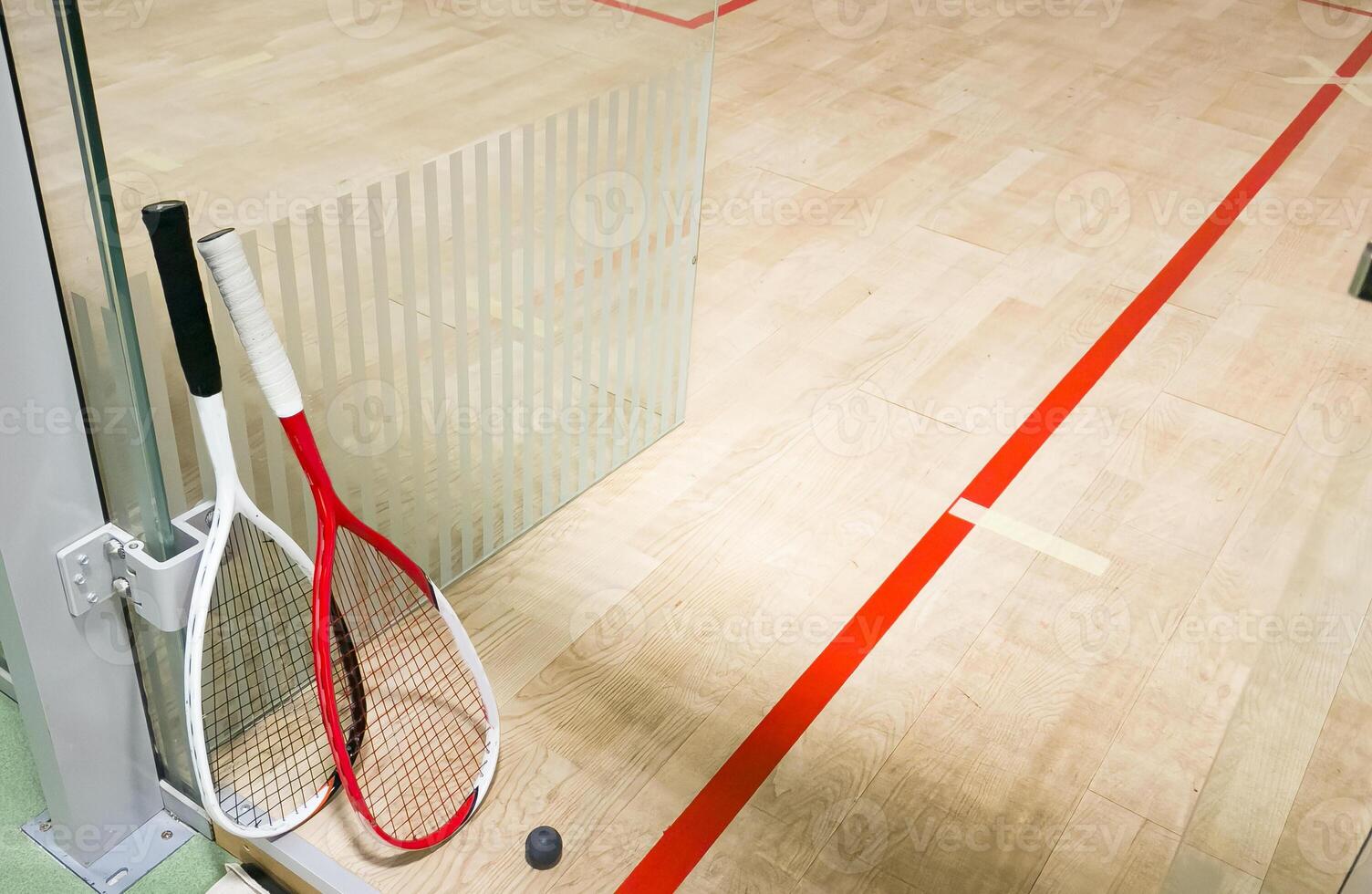 Squash Rackets And a Ball on a Wooden Court Floor. Sport Theme. photo