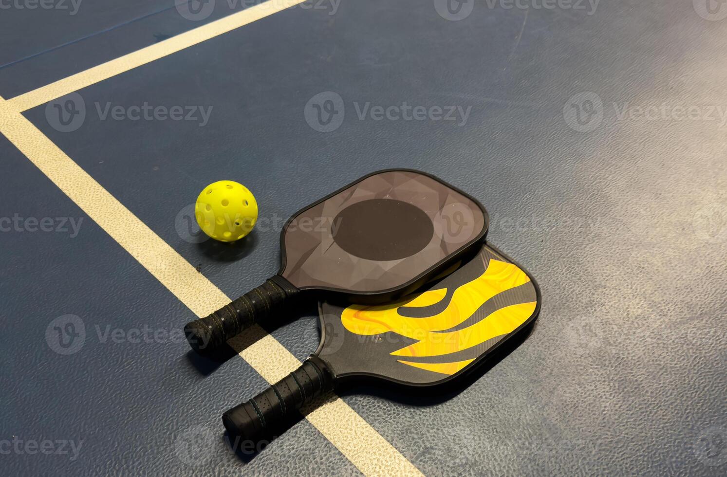 A Pickleball Racquet's on blue court photo
