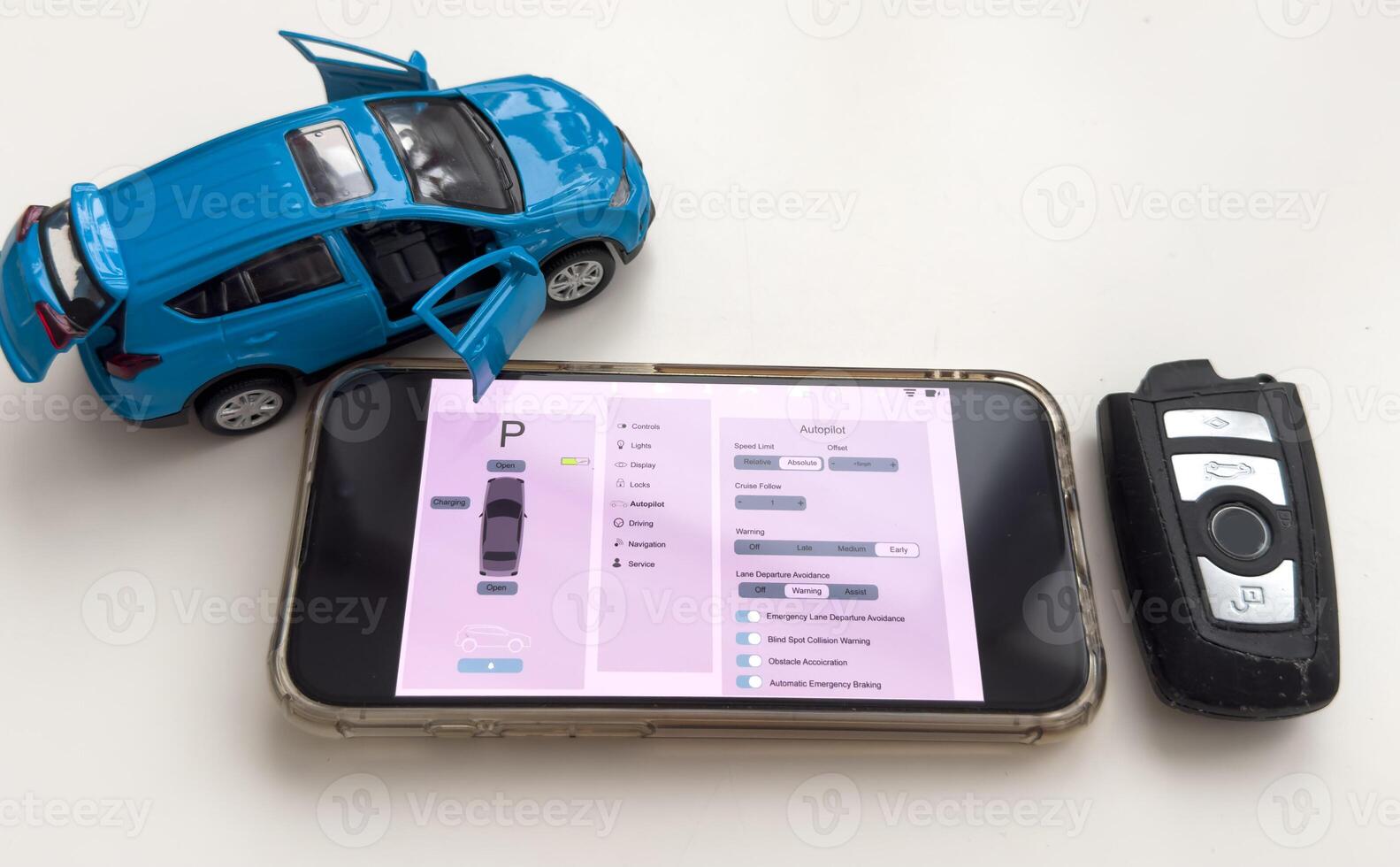Car security concept - key with remote alarm control and smartphone photo