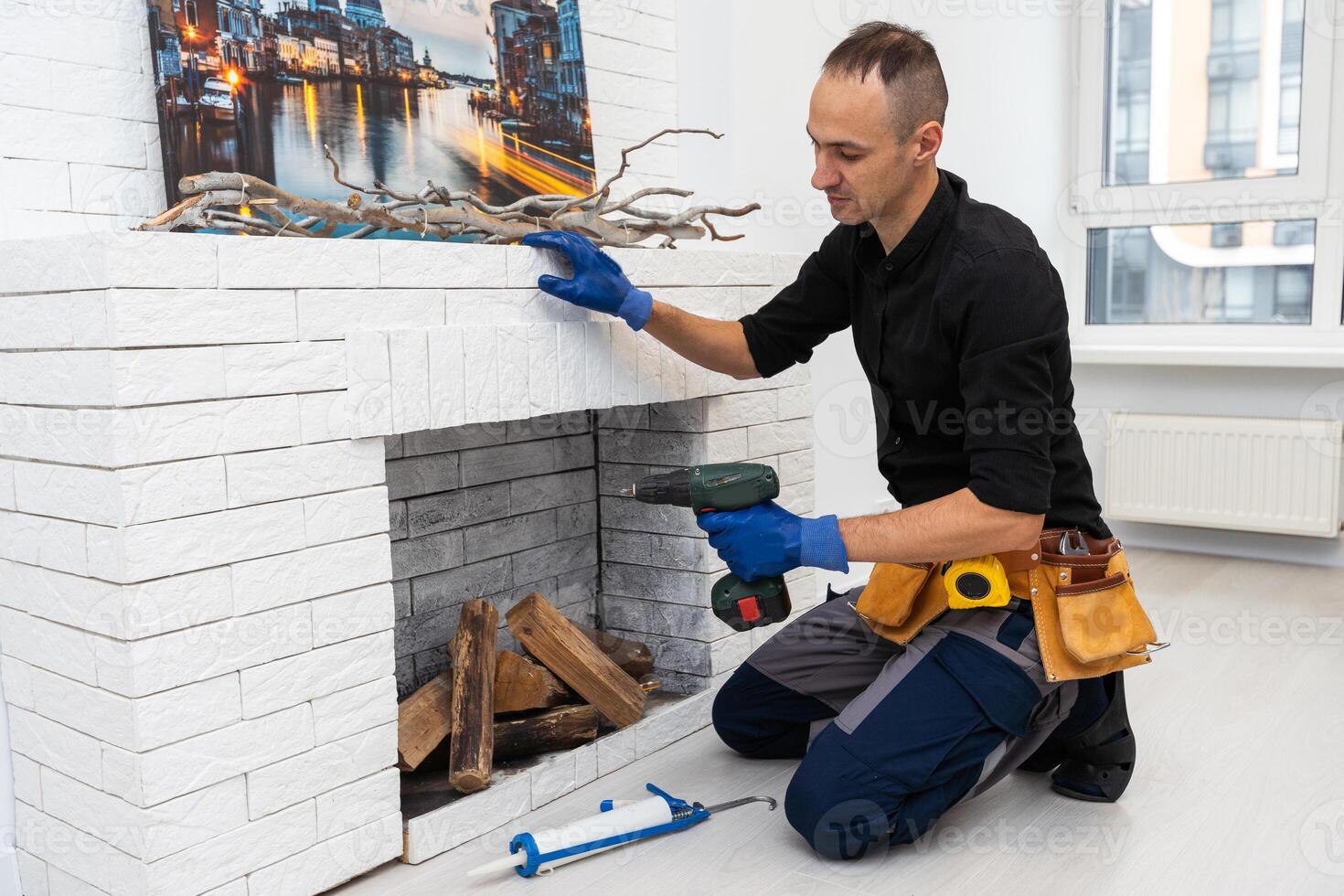 Service technician repairing a fireplace in a home photo