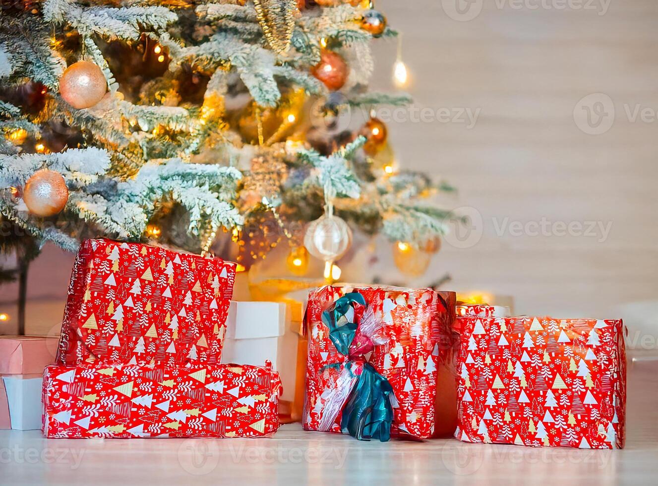 Christmas gifts packed with red,white,paper and tapes under decorated tree photo