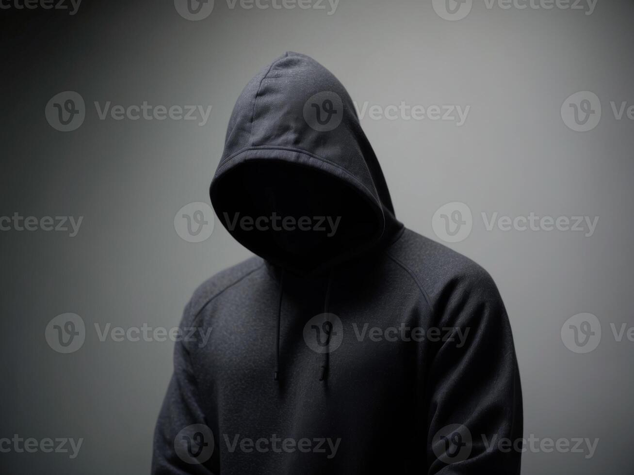 Mysterious figure in a hooded sweatshirt with an obscured face. photo