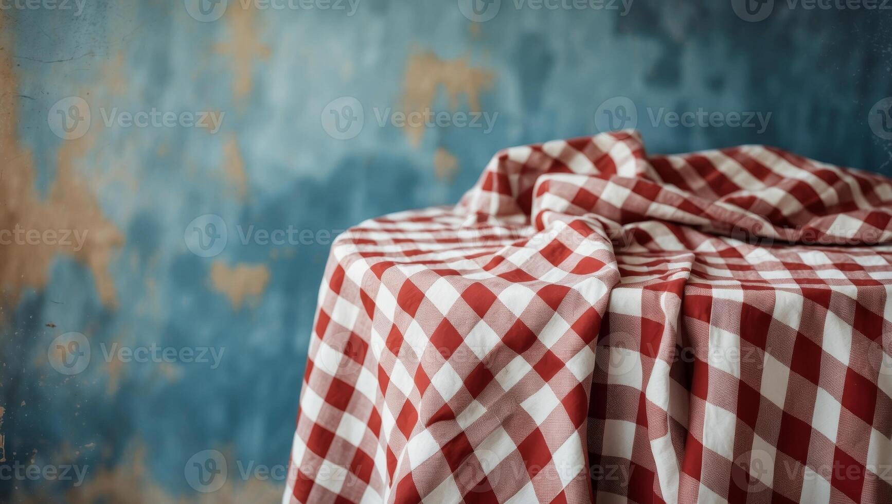 Red and white checkered tablecloth on a textured blue background perfect for rustic dining or event decor visuals photo