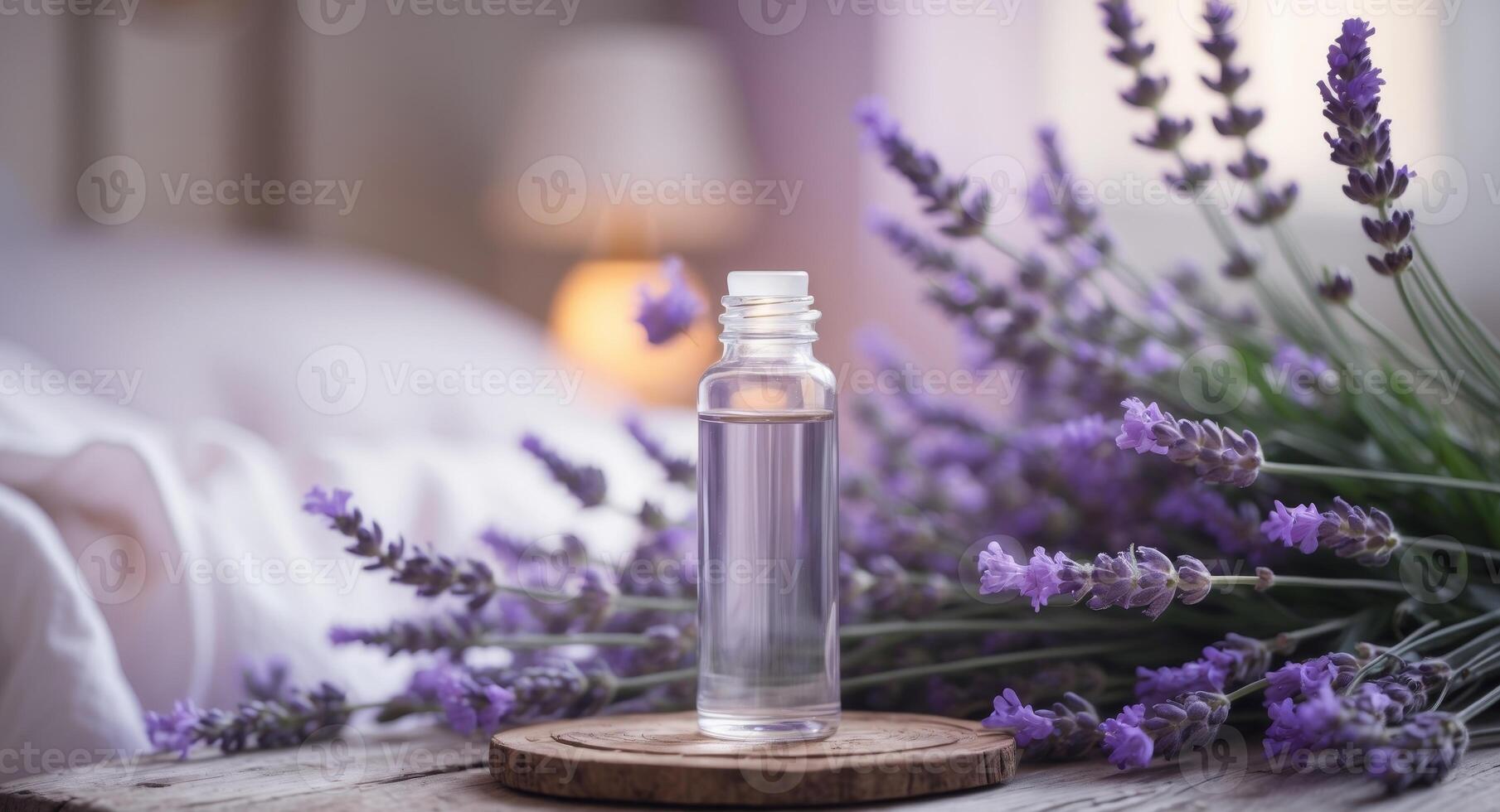 Elegant Glass Bottle of Essential Oil Standing on a Table Surrounded by Lavender Flowers in a Cozy Bedroom Setting with Soft Lighting photo