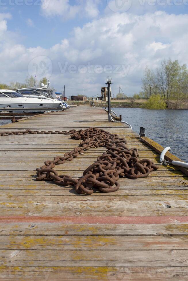 Selective focus. Rusty chain on the pier photo