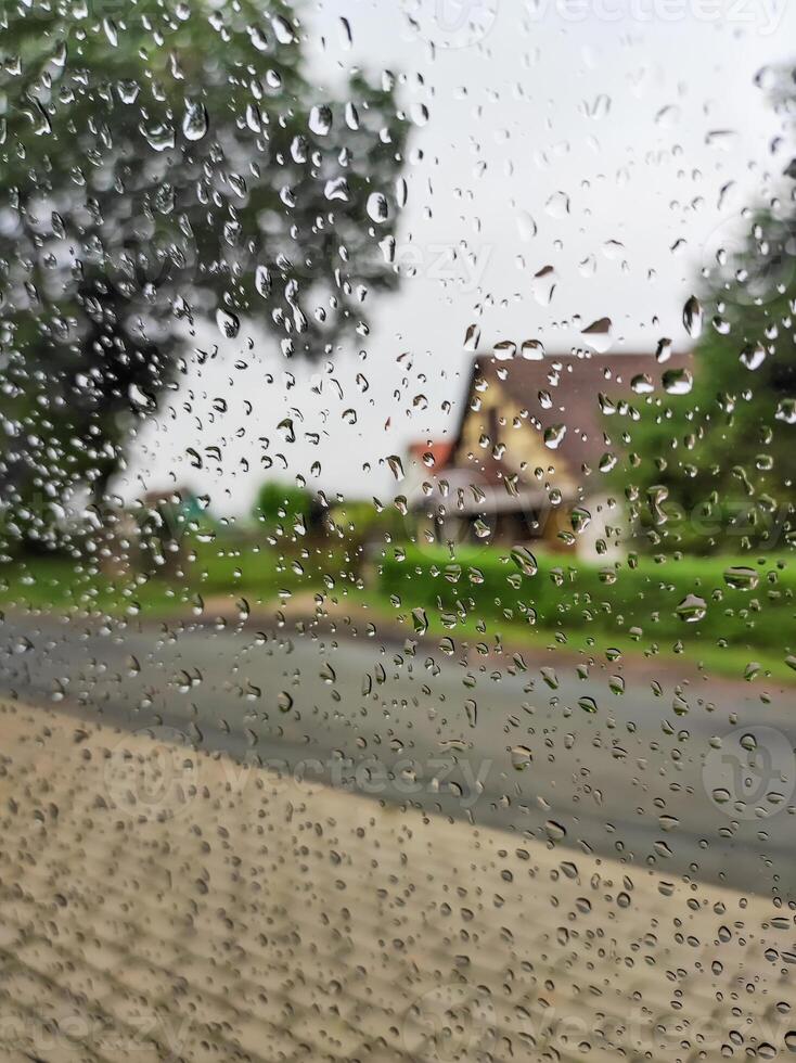 Rainy day, wet glass with raindrops, a look through wet glass. photo