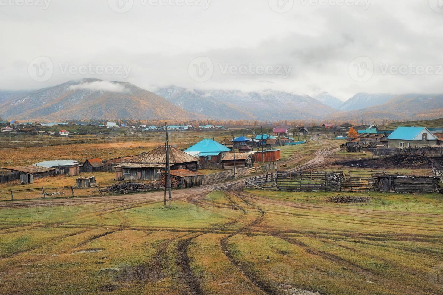Autumn dirt road from a hill to a remote village. Altai photo