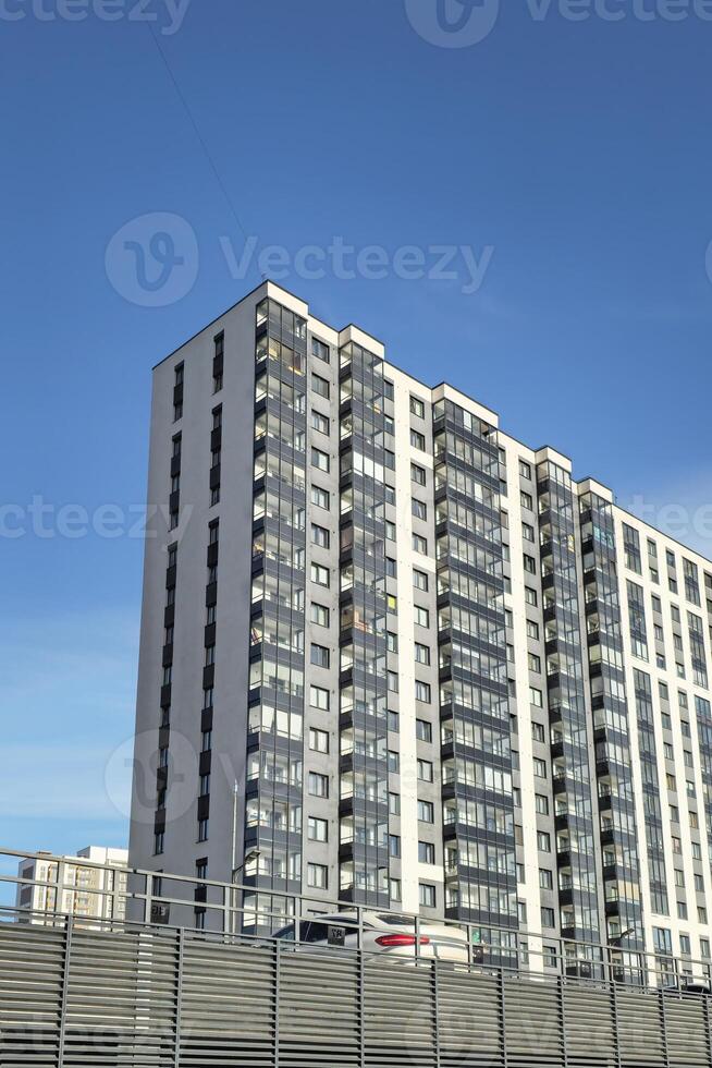 New grey high-rise building in a residential neighborhood. photo