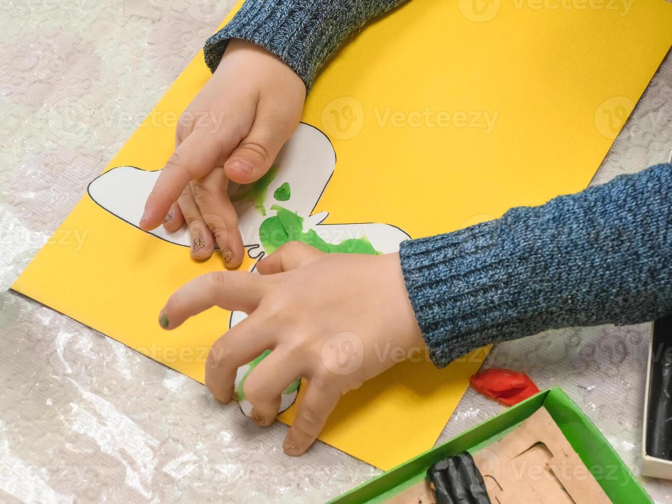 Children's hands sculpt a butterfly from plasticine. Child playing and creating butterfly from play dough. Homemade clay. photo