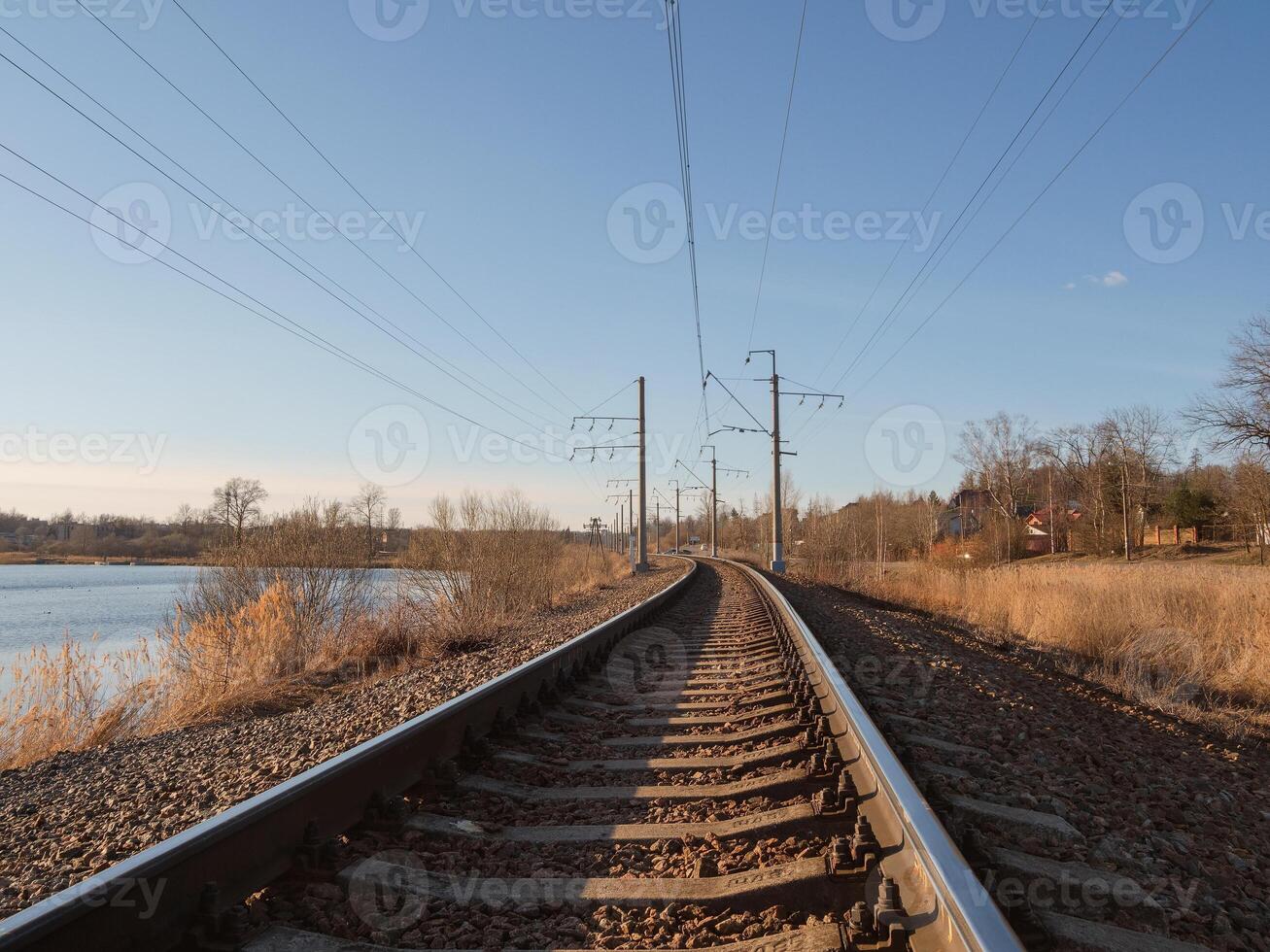 Perspective of rounded rails. Railway track turns and twists between out of focus hills background. Empty rounding and turning single track of railways. Empty railway track, single rail. photo