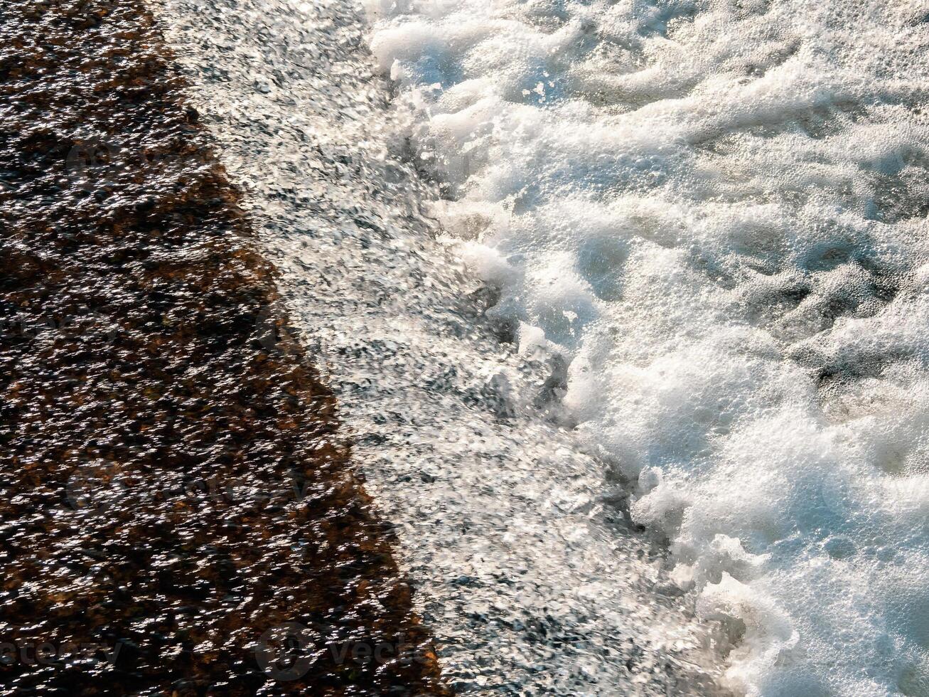 Flowing water texture. White water foam, small waterfall photo