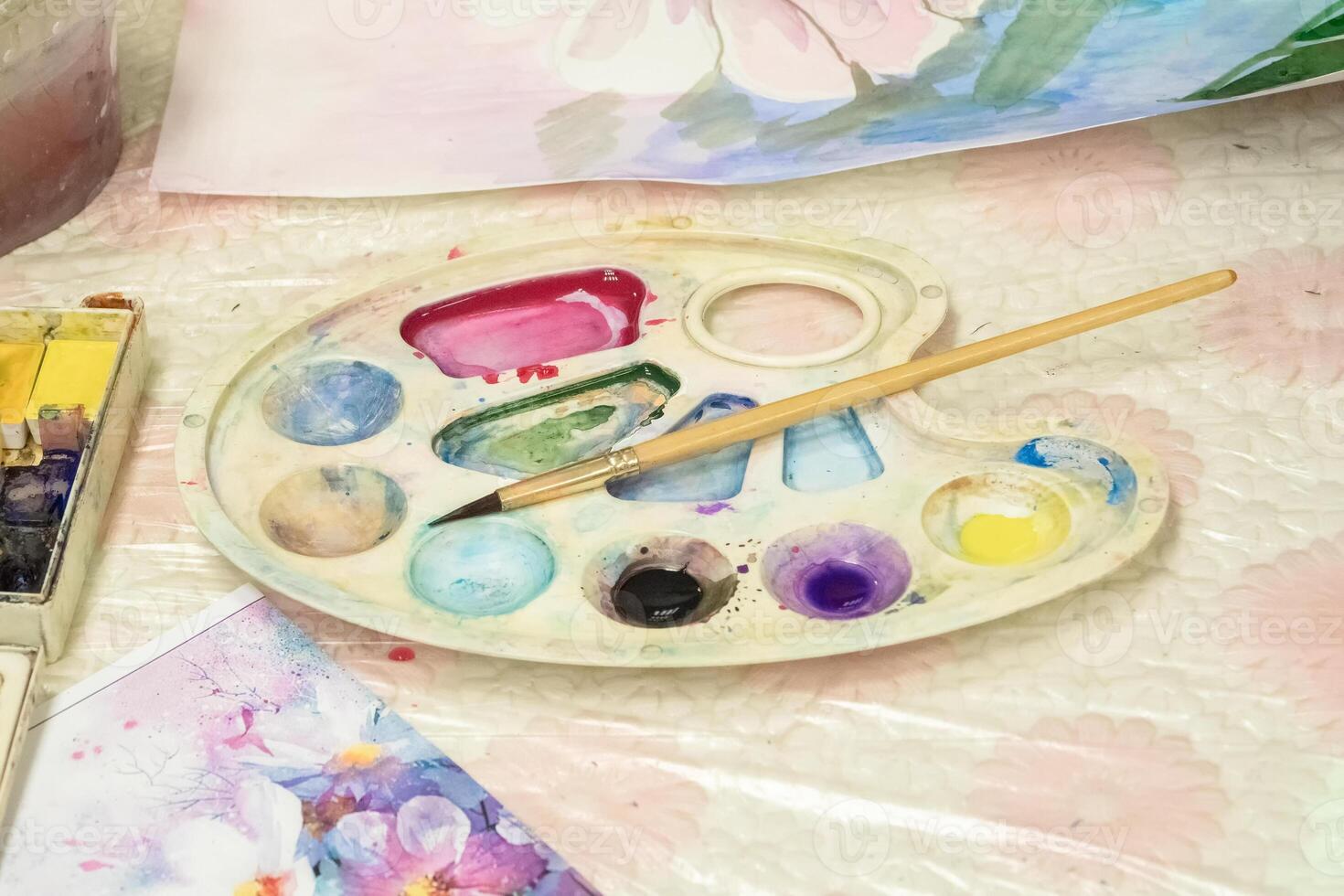 Brush and watercolor palette on the dirt table. Paints and brushes for drawing. photo