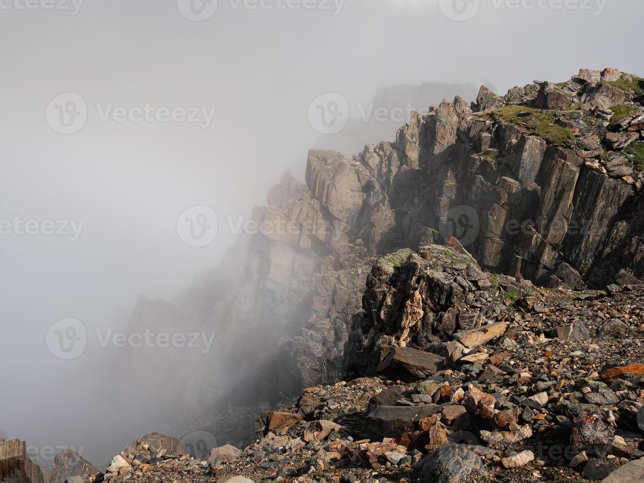 Foggy mountain view from cliff at very high altitude photo