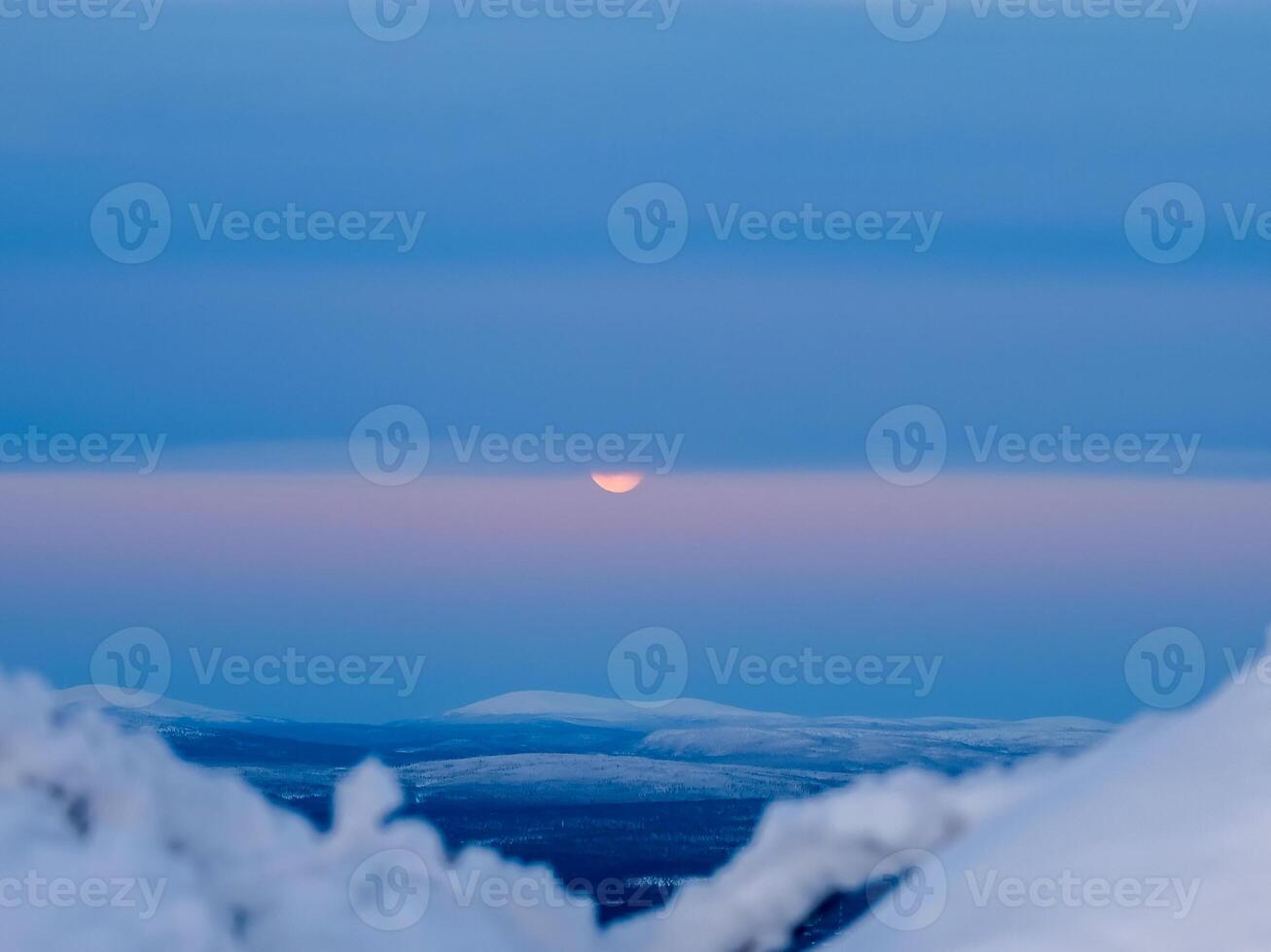 Moon partly hidden behind clouds. Part of the full moon behind the clouds. Arctic evening sky with moon. photo
