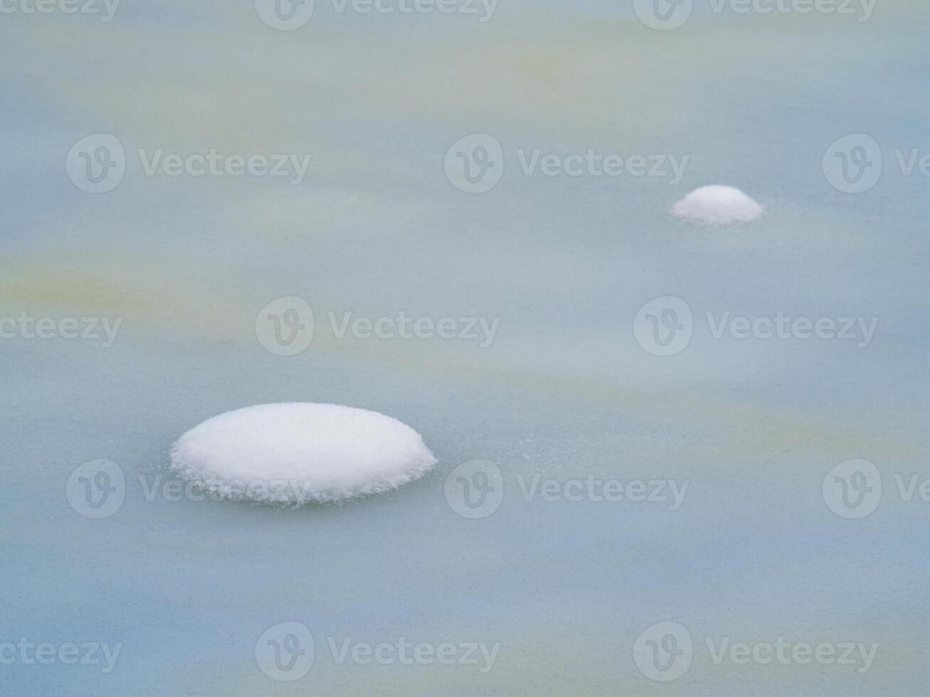 Selective focus. Spring ice, snowy round islands on melting ice. Abstract natural background. photo
