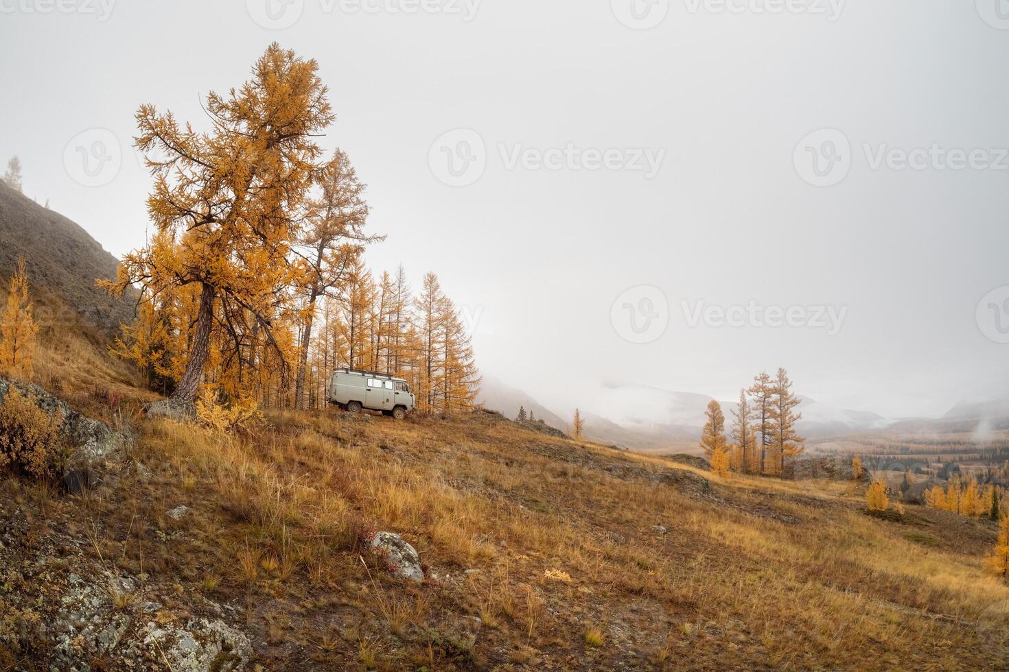 Traveling in the autumn mountains by car. Car on forest trail, from the side view photo