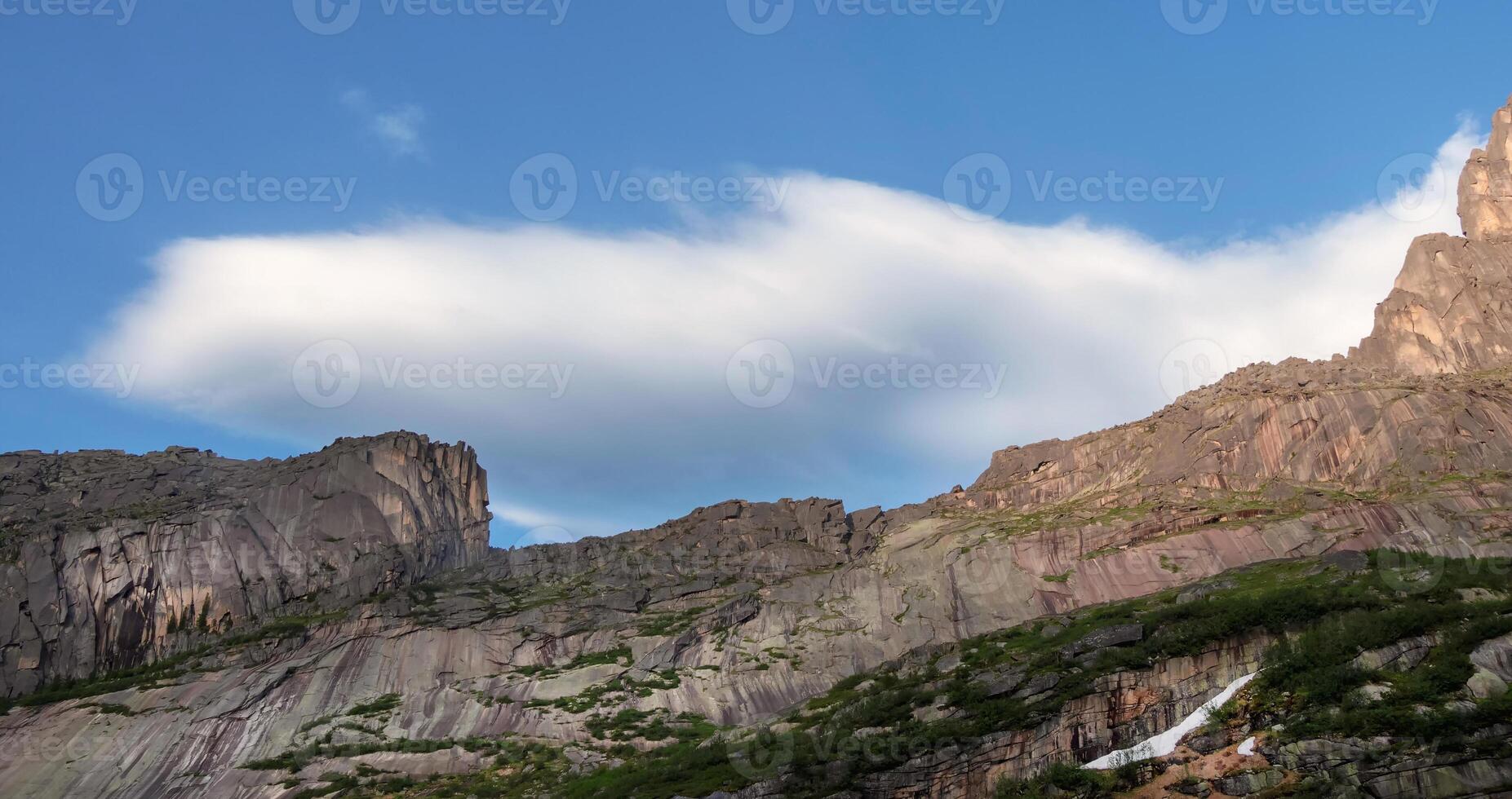 Scenic minimalist panoramic landscape with white clouds in blue sky over rock. Simple minimalism with white clouds in blue sky. Colorful sky scenery. Atmospheric day cloudscape. photo